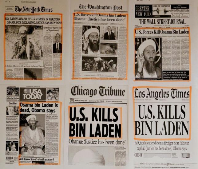Newspaper headlines and clippings are posted on a wall inside a staff office at the White House in Washington
