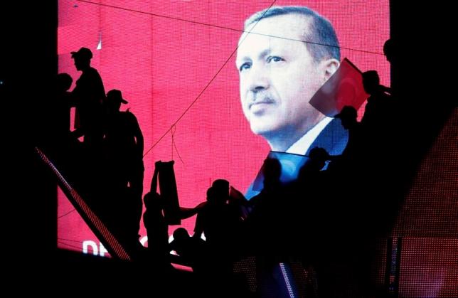Turkish Supporters are silhouetted against a screen showing President Tayyip Erdogan during a pro-government demonstration in Ankara