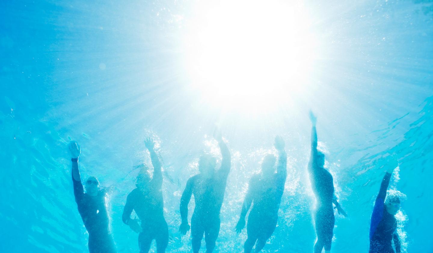 Triathletes in wetsuits underwater
