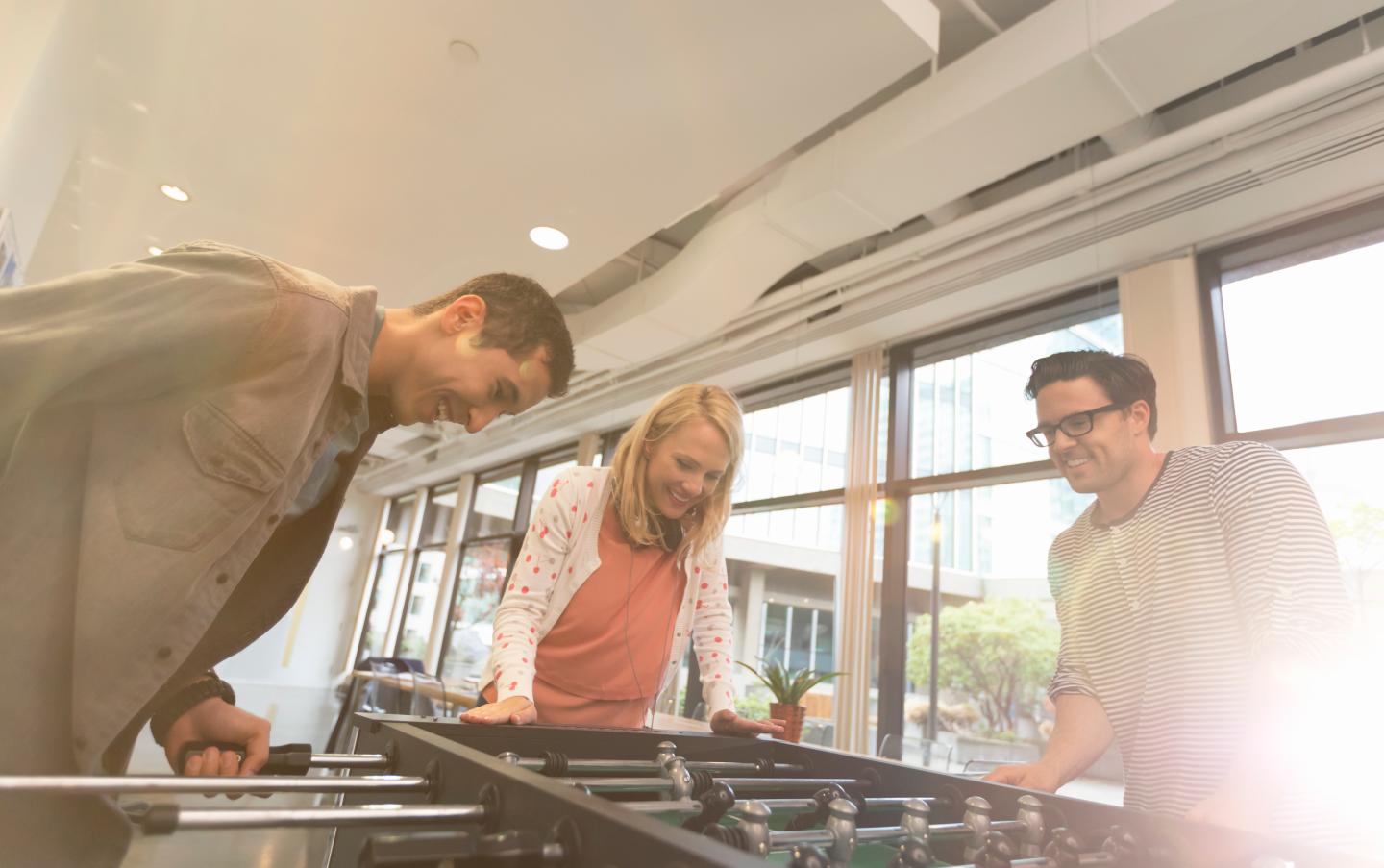 Business people playing table football in office