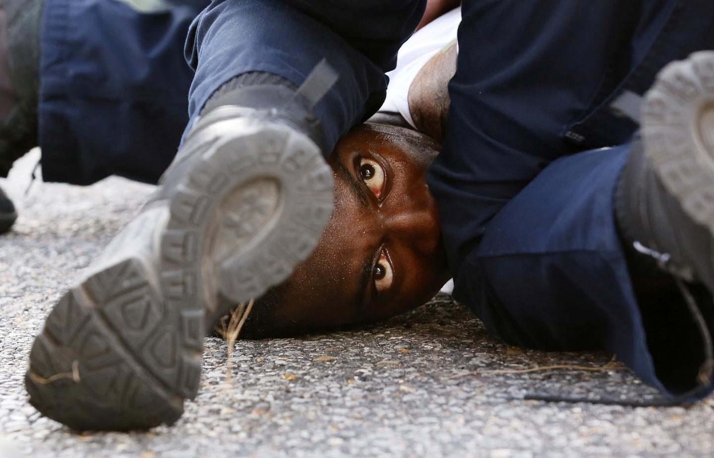 A man protesting the shooting death of Alton Sterling is detained by law enforcement near the headquarters of the Baton Rouge Police Department in Baton Rouge, Louisiana