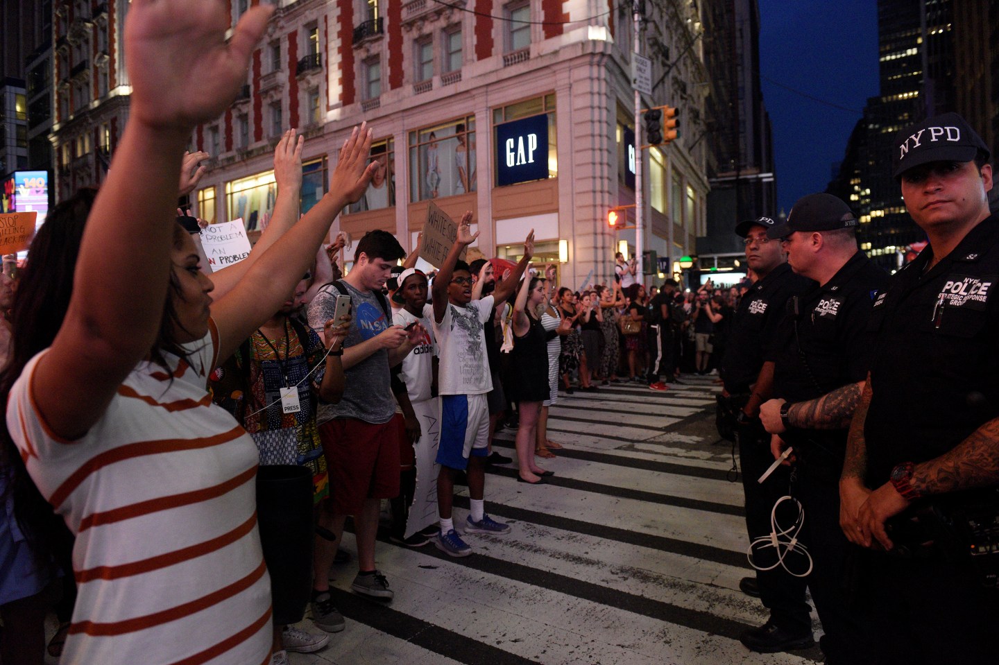 People hold their hands in the air as they yell "hands up, don't shoot!" during a protest for the killing of Alton Sterling and Philando Castile in the Manhattan borough of New York