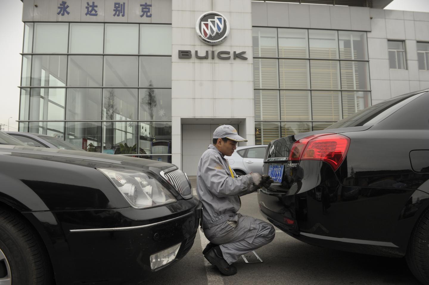 A mechanic works on a Buick at a General
