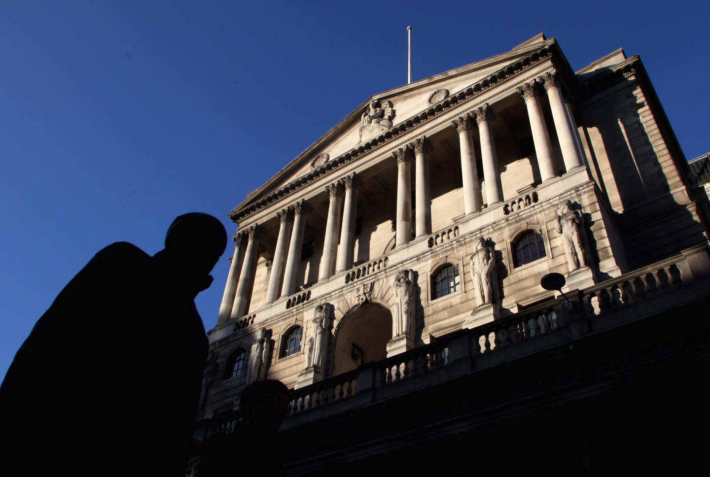 A city worker walks past the Bank of Eng