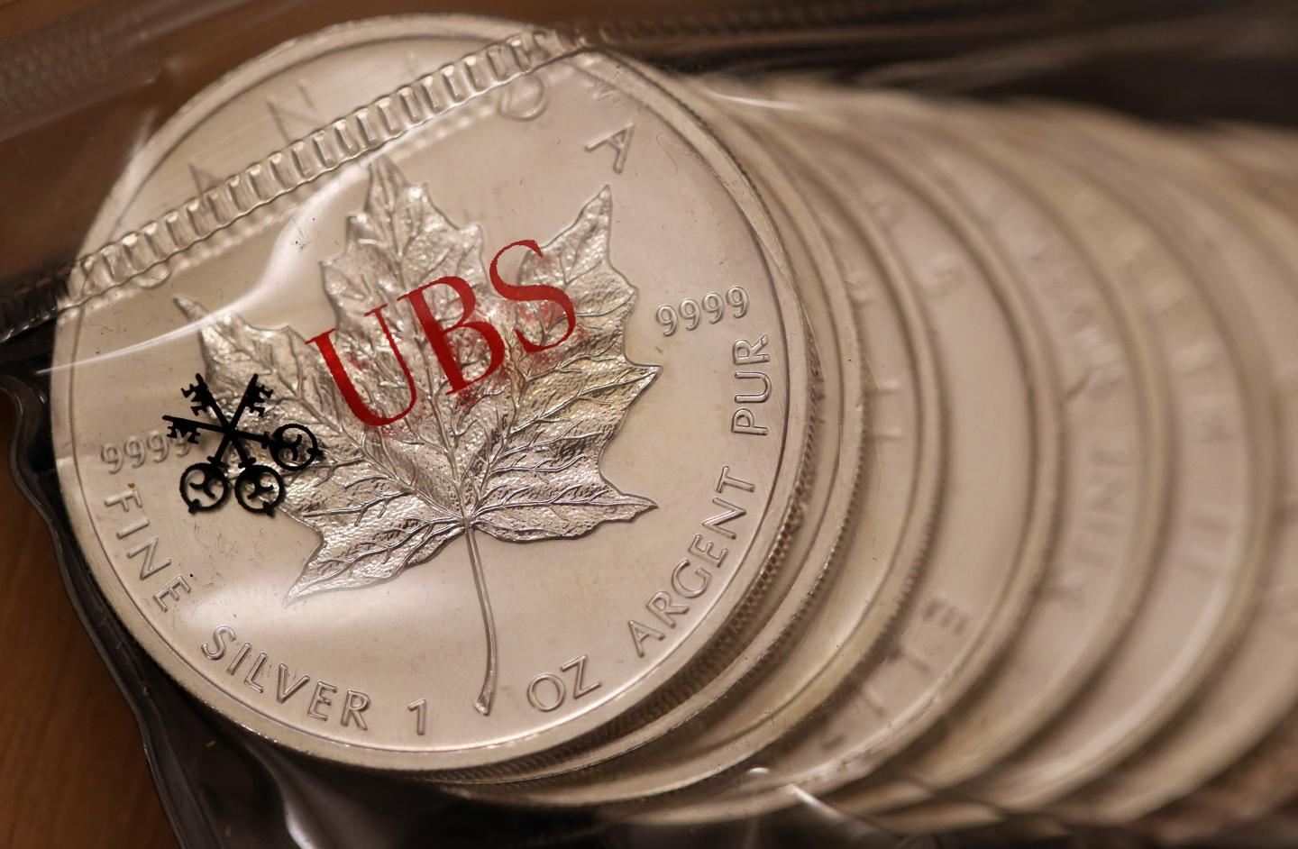 One ounce silver coins sit stored inside a UBS branded plastic bag in London.