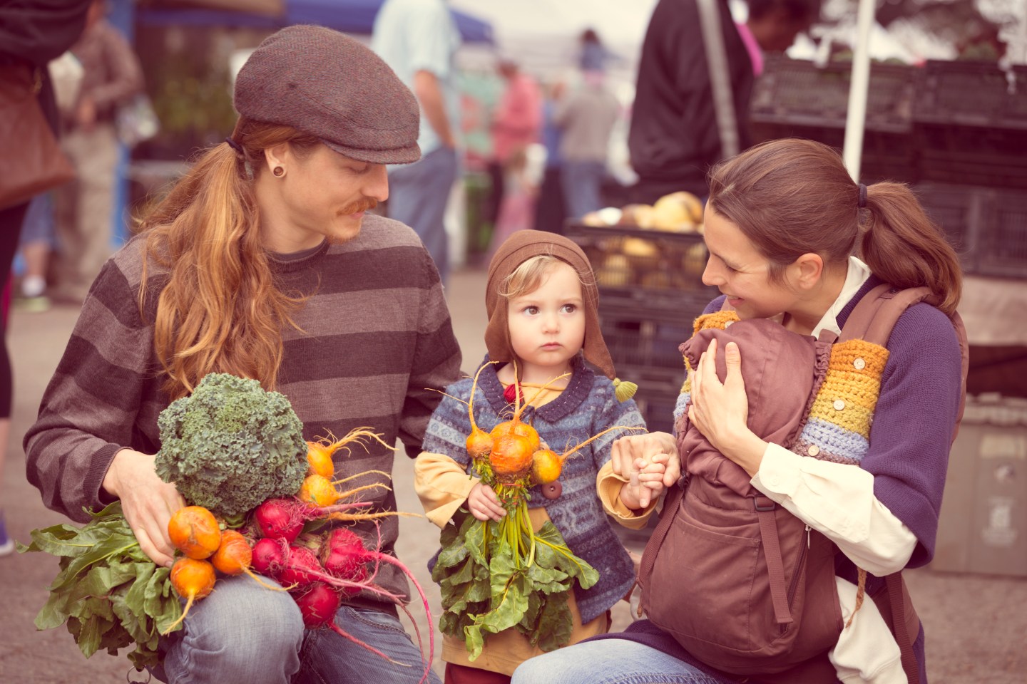 Young Hipster family with produce from outdoor farmers market