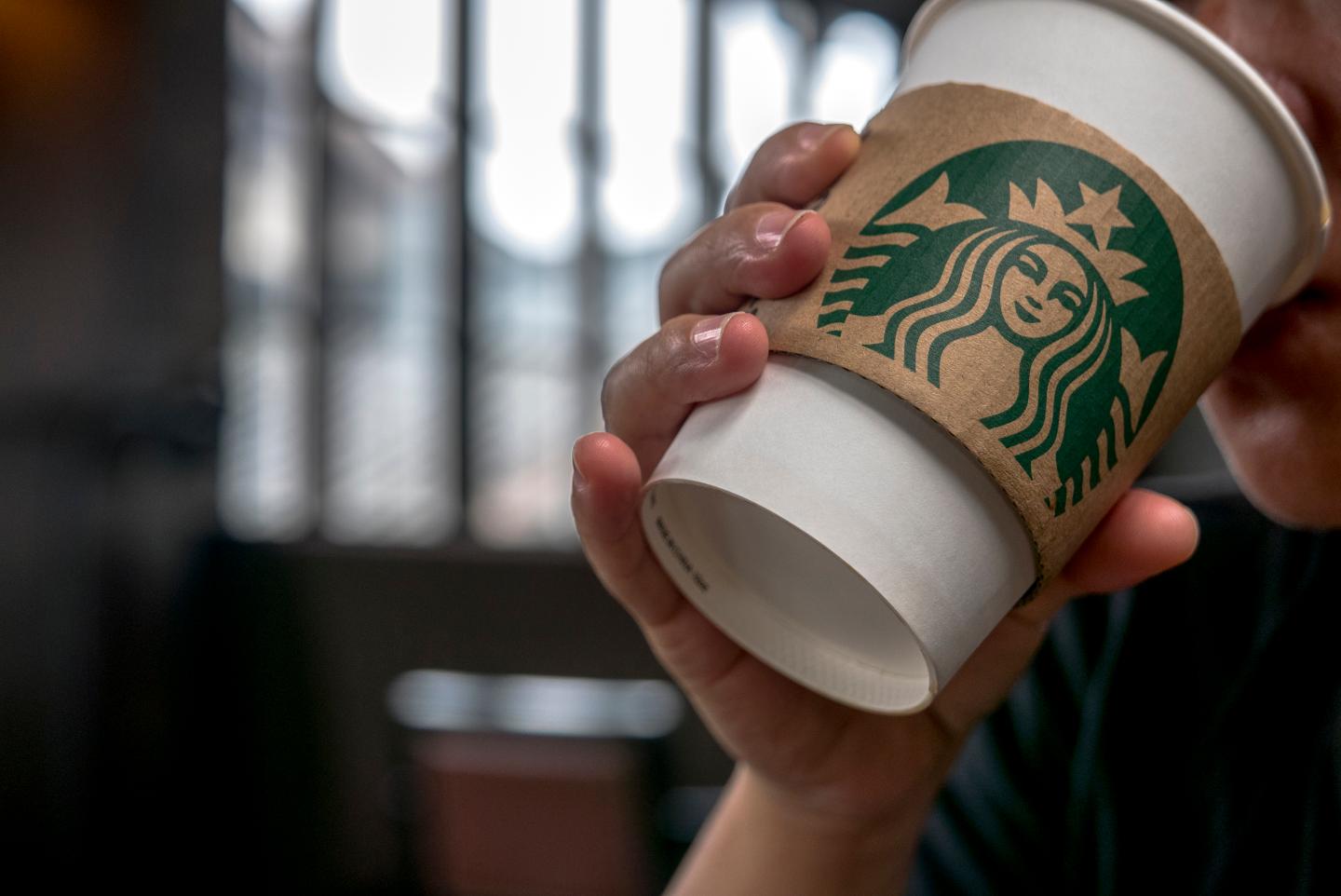 Customer drinks coffee in a Starbucks cafe. Starbucks is