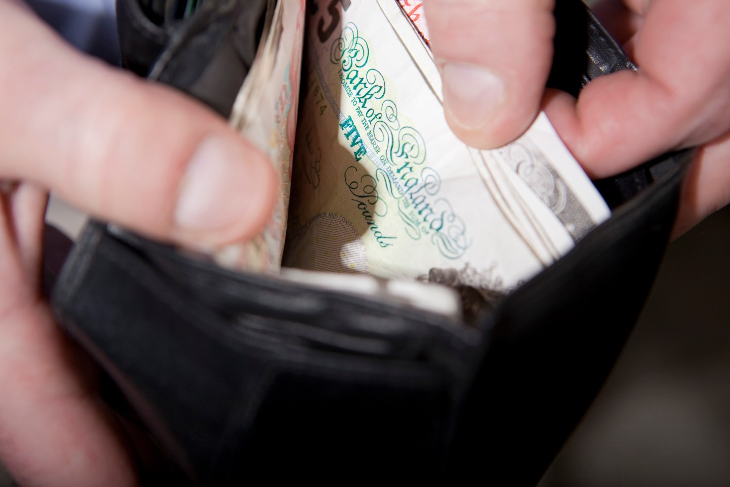 A man checks the money his wallet.