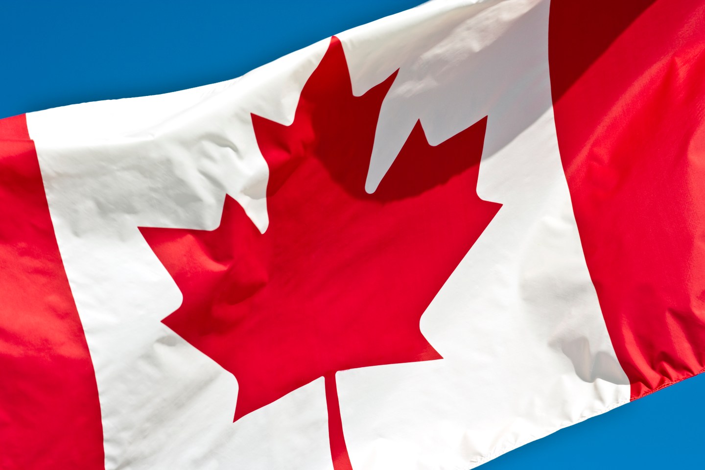 Canadian Flag waving in the blue sky