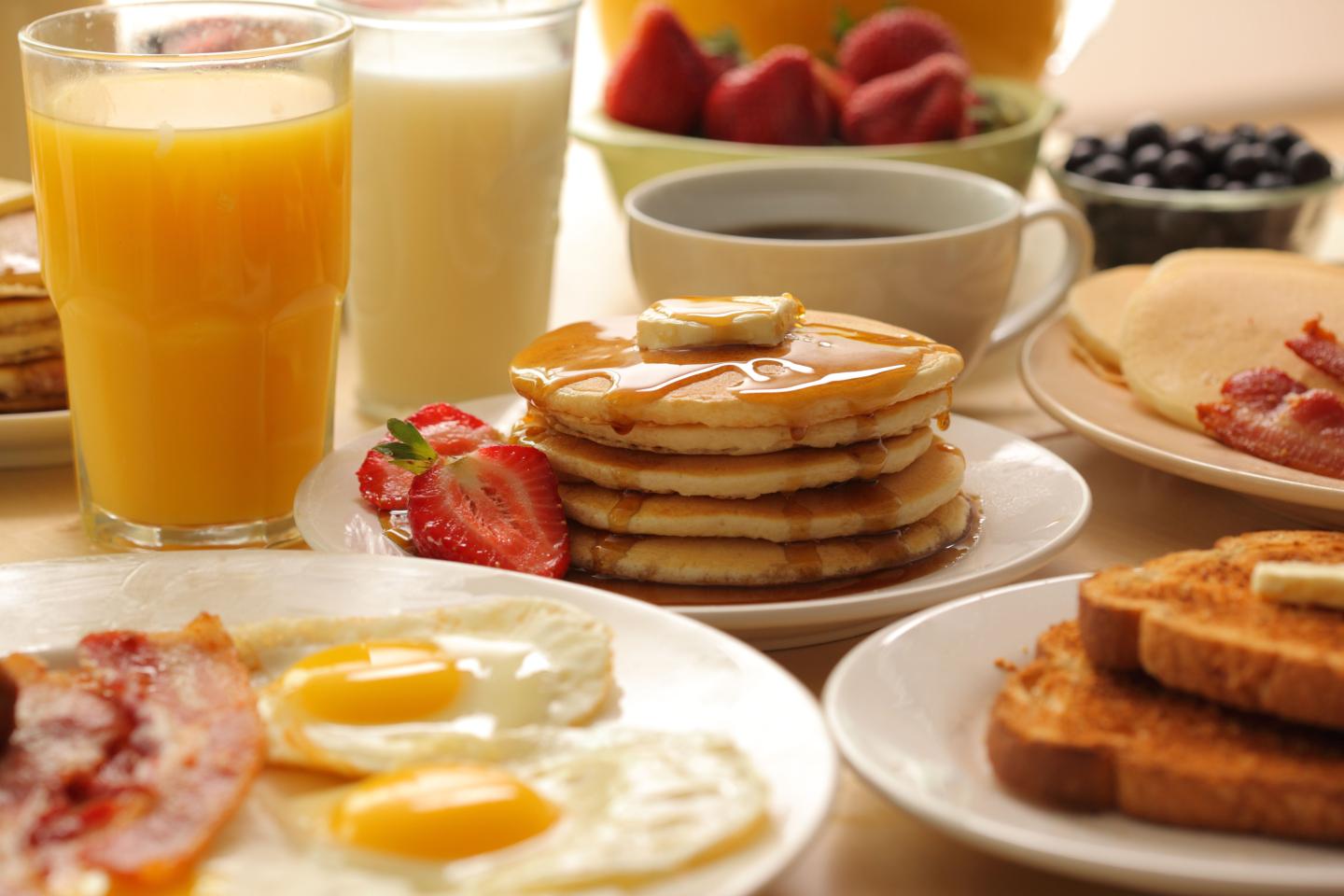 Breakfast pancakes, fruit, eggs, bacon and toast