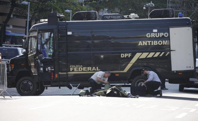 Bomb squad agents control the area near the finishing line of the men's cycling road race at the 2016 Rio Olympics after a loud blast was heard, in Copacabana, Rio de Janeiro