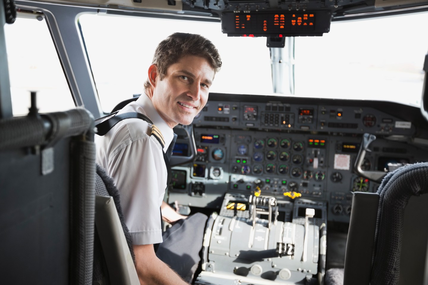 Portrait of male pilot sitting in airplane cockpit