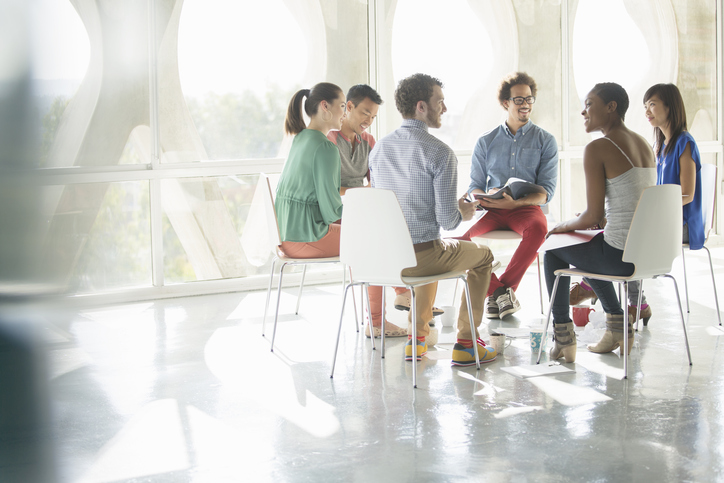 Creative business people meeting in circle of chairs