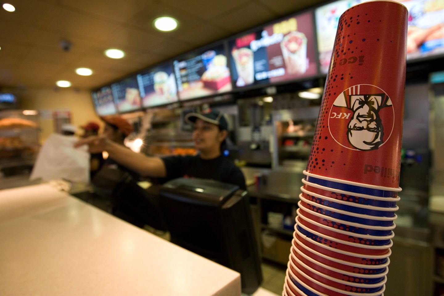 A KFC employee serving a hungry customer in the restaurant on Oxford Street, Central London
