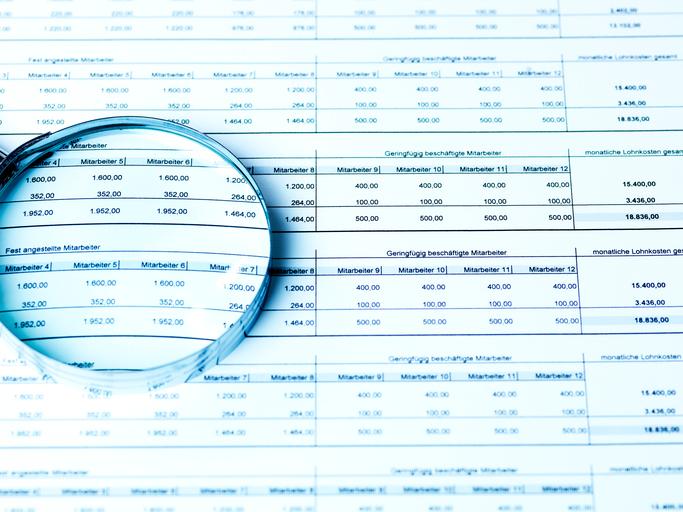 High Angle View Of Magnifying Glass On Document In Office
