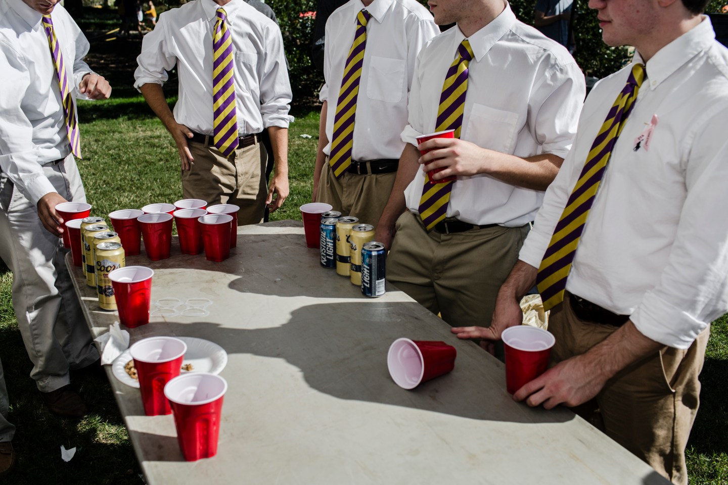 Fraternity pledges wear ties in Louisiana State University colors while playing drinking games in Baton Rouge, La.