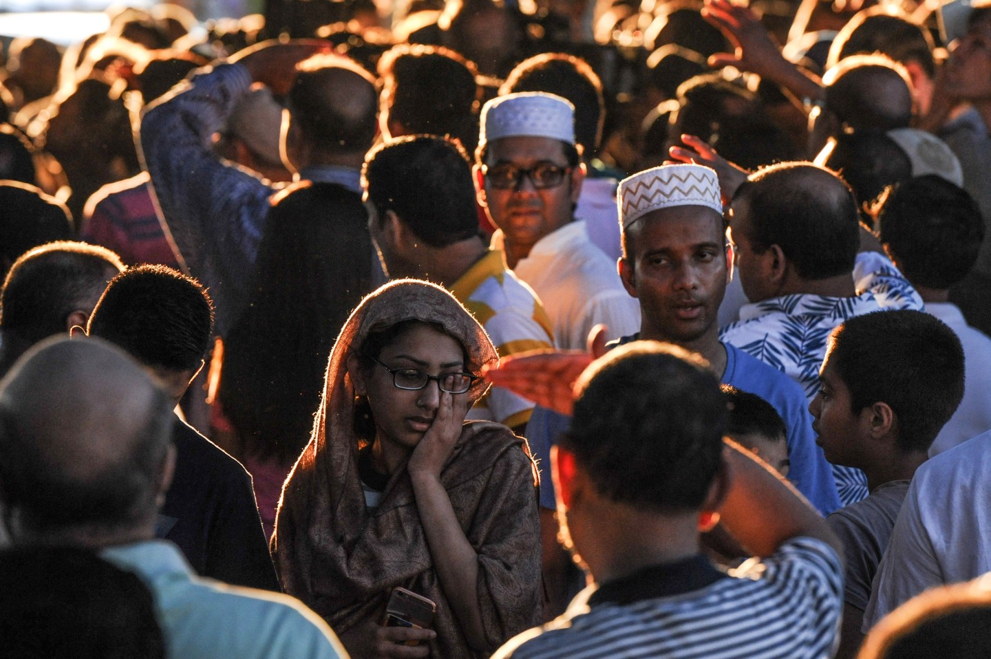 A crowd of community members gather at the place where Imam Maulama Akonjee was killed in the Queens borough of New York City