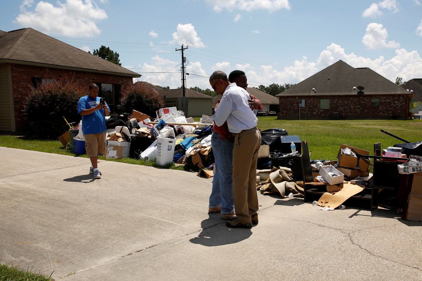 U.S. President Barack Obama greets a homeowner as he tours a flood-affected neighborhood in Zachary