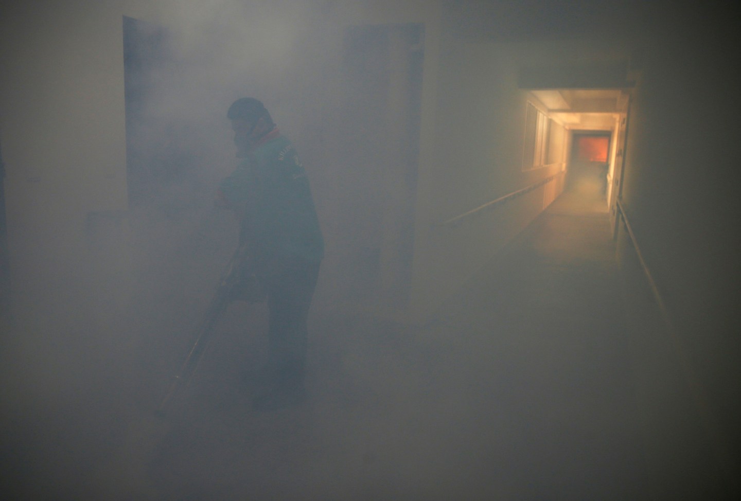 A worker fogs the corridor of a public housing estate in the vicinity where a locally transmitted Zika virus case was discovered, in Singapore