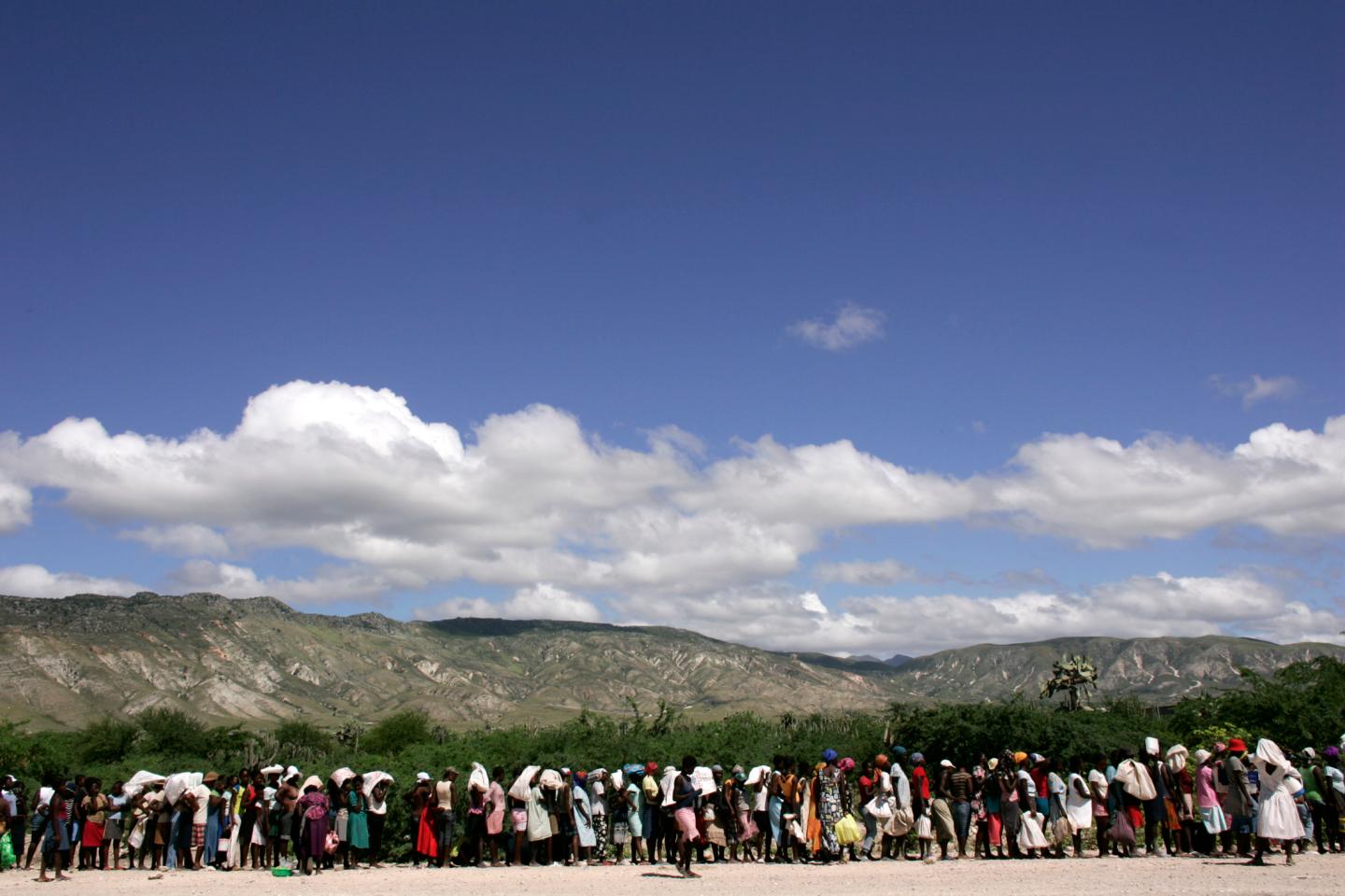 Haitian women stand in line waiting to get food donated by the NGO CARE and World Food Program "WFP" after flooding in the town of Gonaives