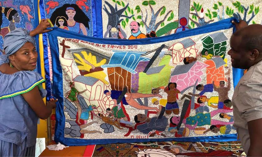 Haitian flag makers unfurling a piece at the International Folk Art Market in Santa Fe, New Mexico