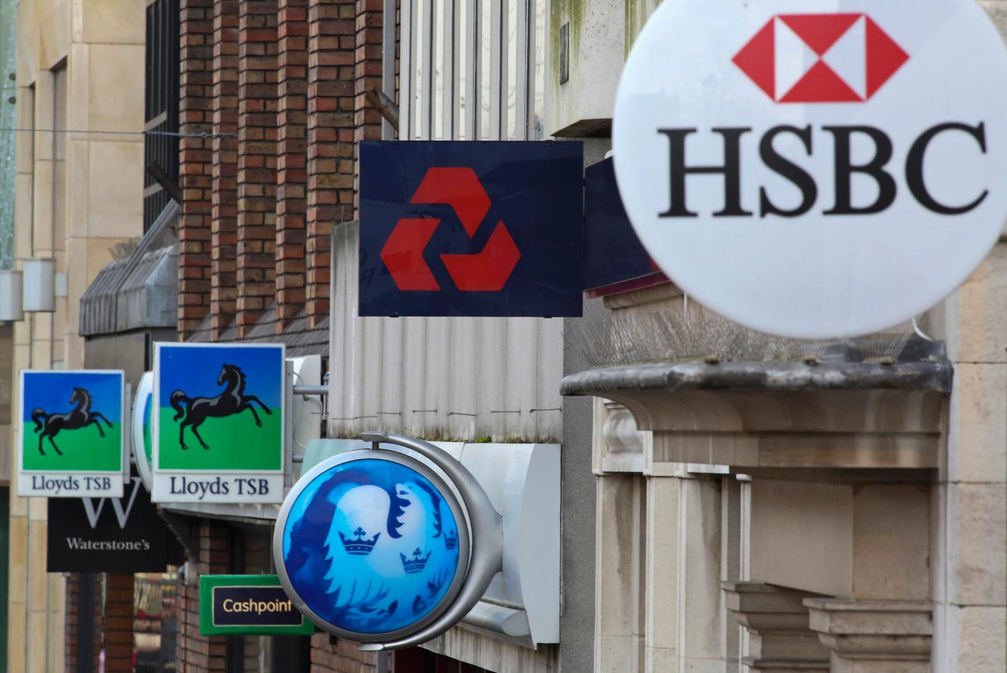 Signs sit outside branches of banks in the UK.
