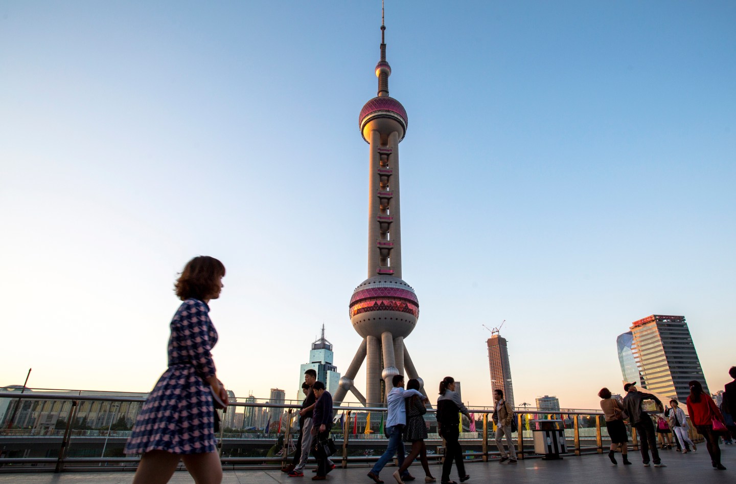 People walk on the overpass bridge under the Pearl of the