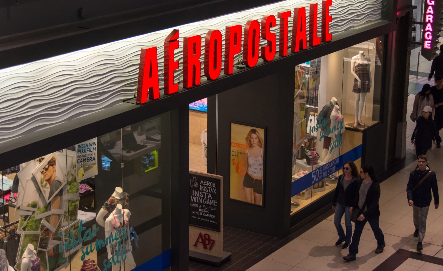 Shoppers passing by Aeropostale retail store inside a mall,