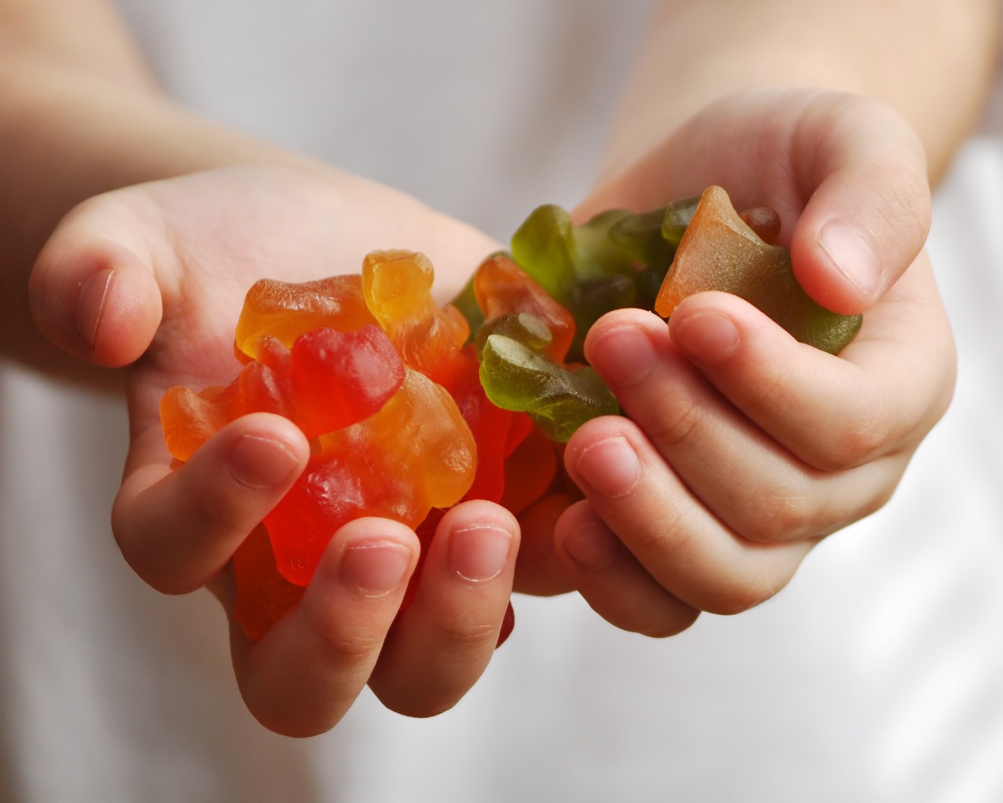 Gummy candies in child hands: Children's hands hold a lot of
