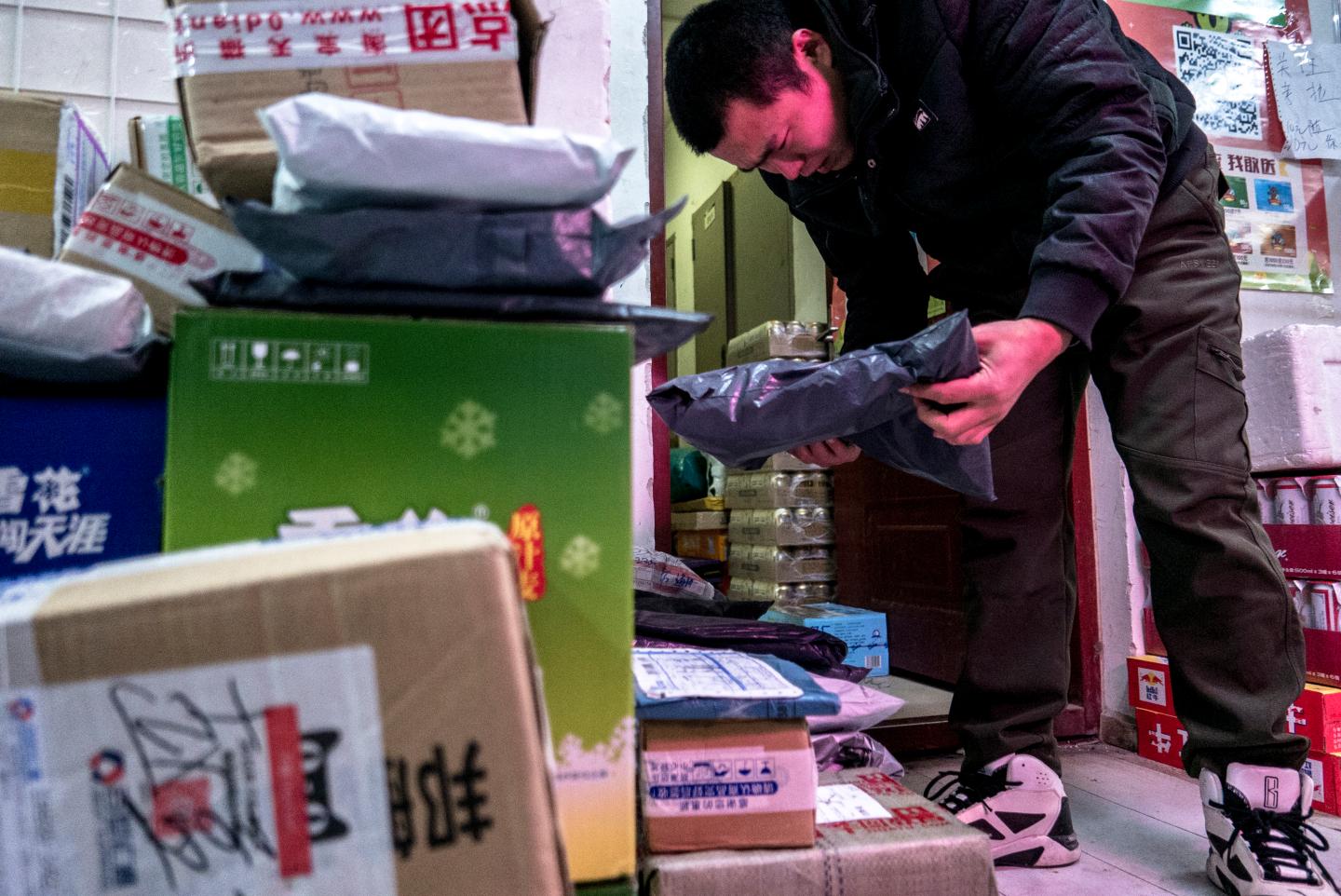 Packages are piled up in a small shop's Cainiao service