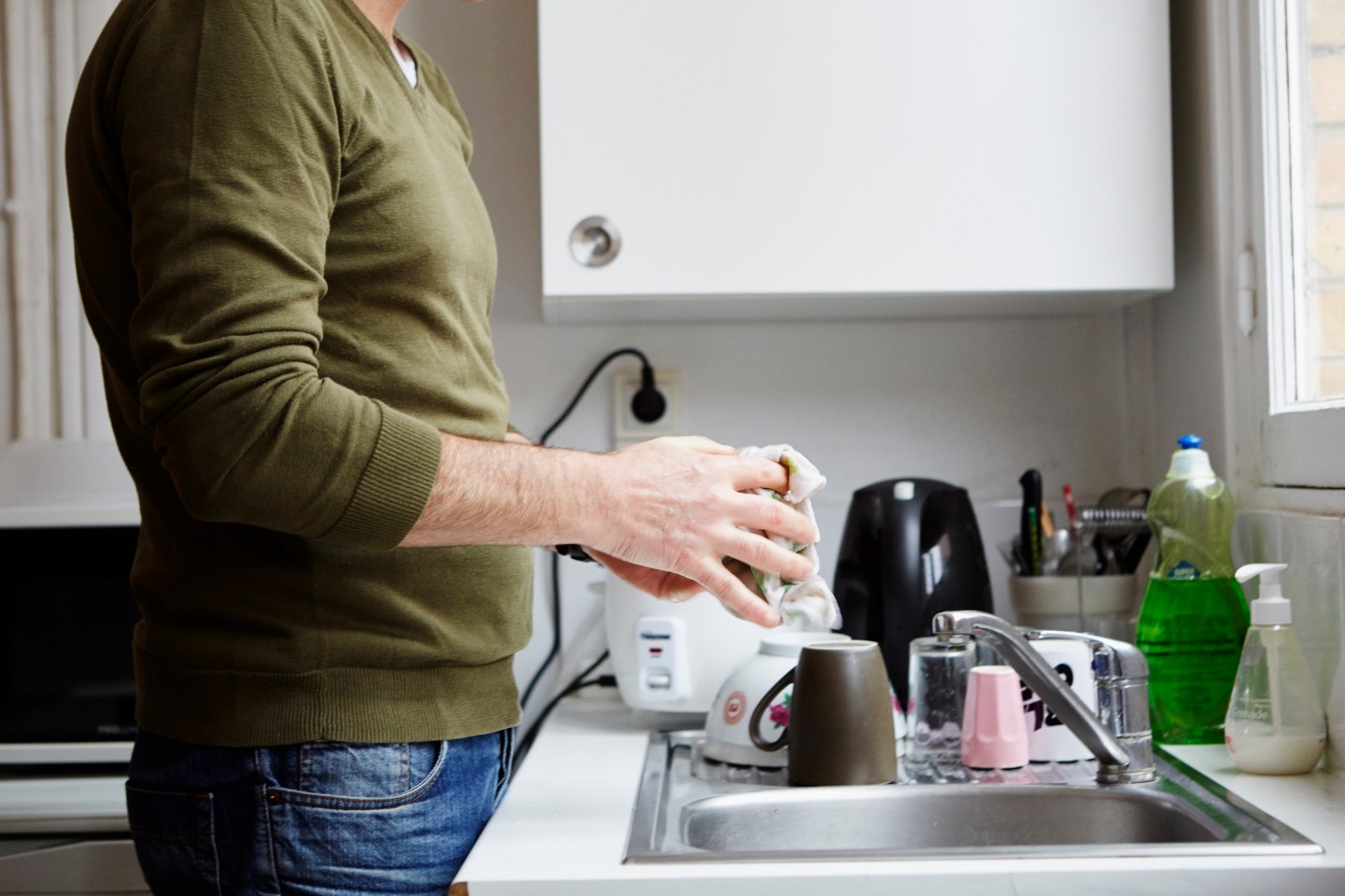 Mature man washing up in kitchen