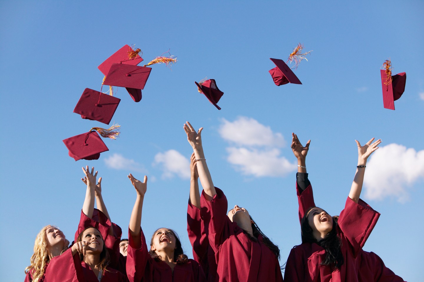 Line of Female Students Throwing Their Mortar Boards in the Air at Graduation