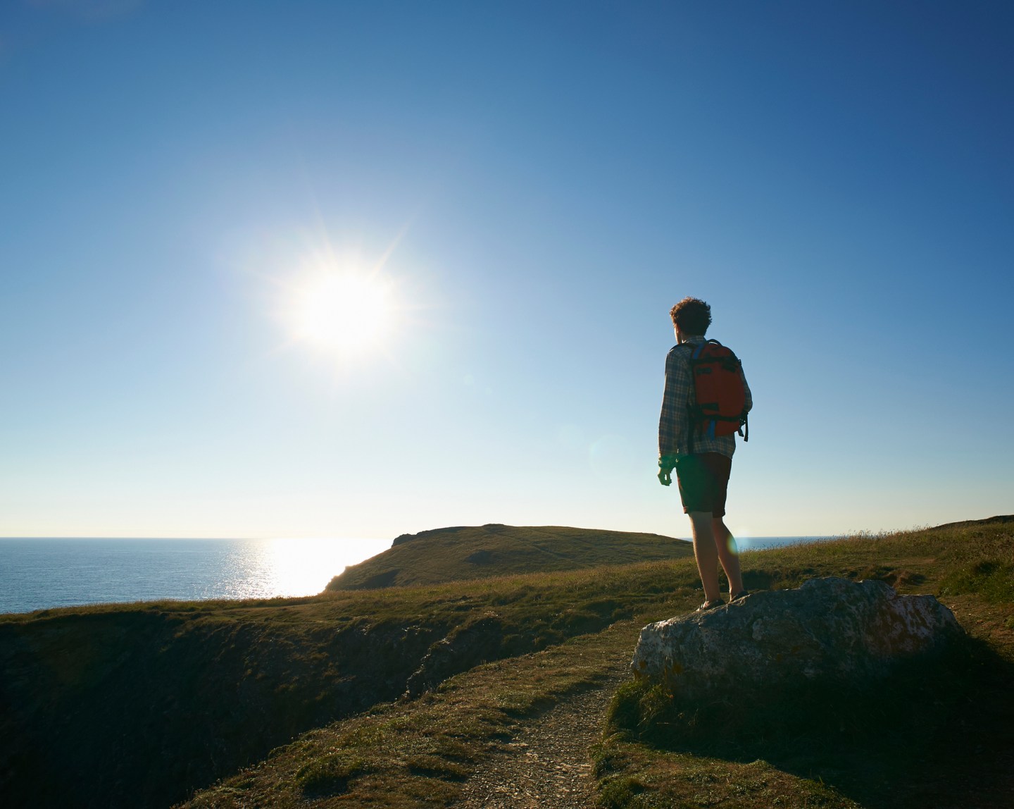 Hiker looking out to sea from Atlantic coastline.