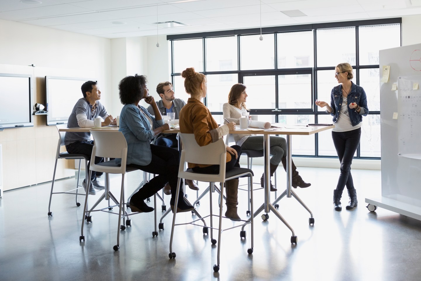 Businesswoman at whiteboard leading meeting in conference room