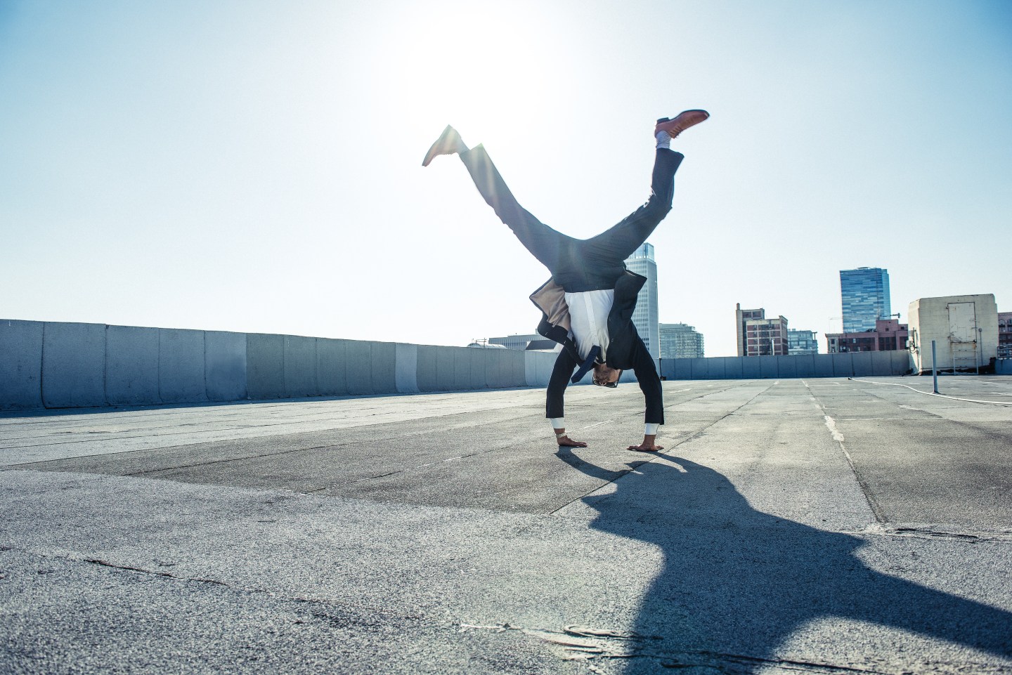 Businessman doing handstand on roof terrace, Los Angeles, California, USA