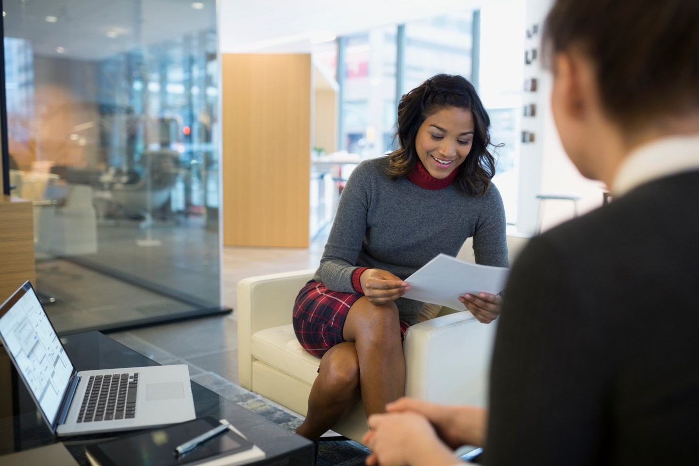 Businesswomen reviewing paperwork in office lobby