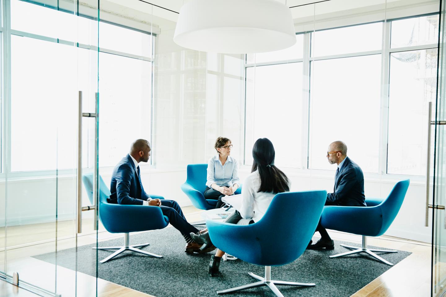 Mature businesswoman leading meeting in office
