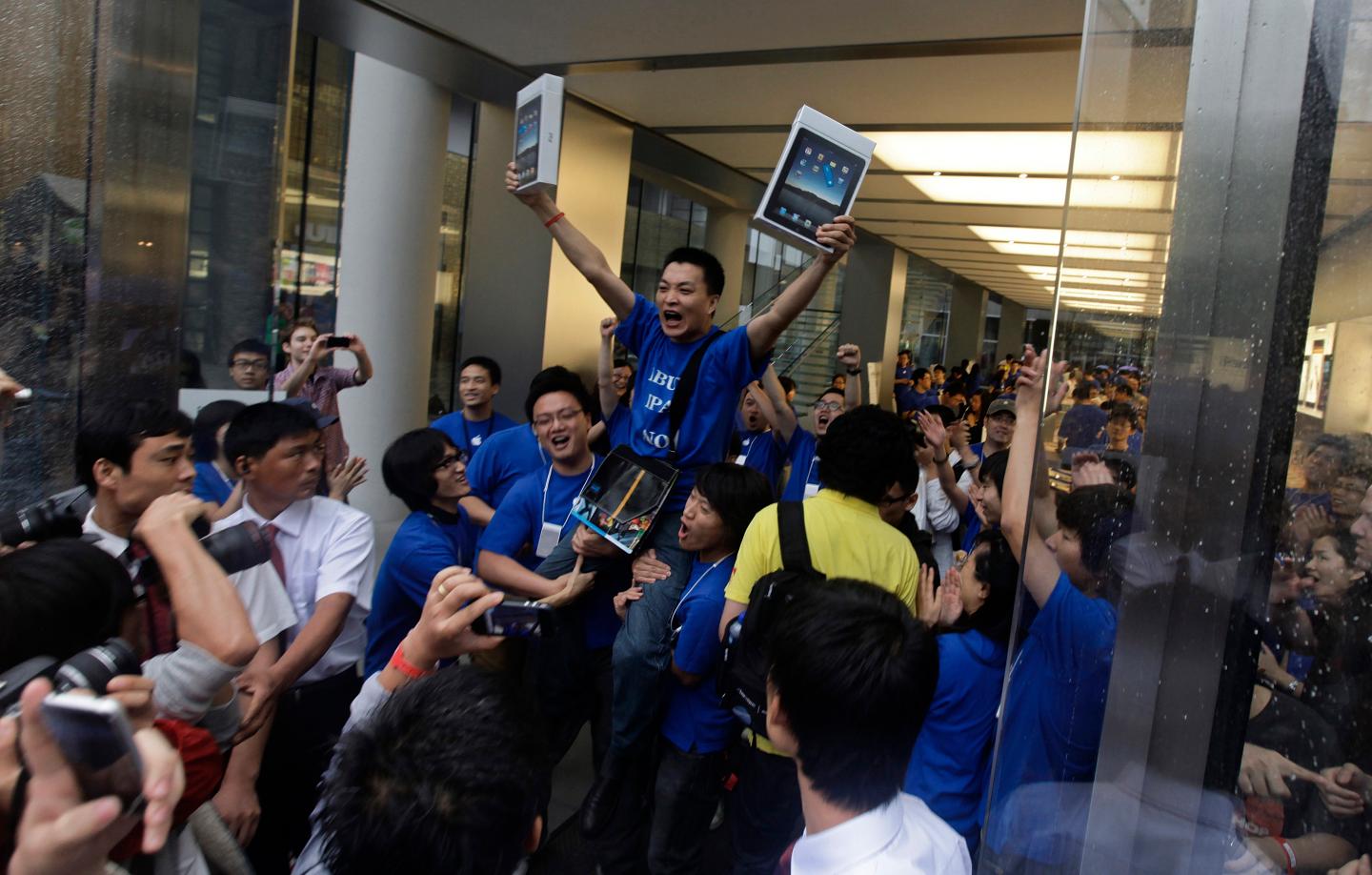 Customer Han Ziwen holds up his iPads at an Apple flagship store in Beijing