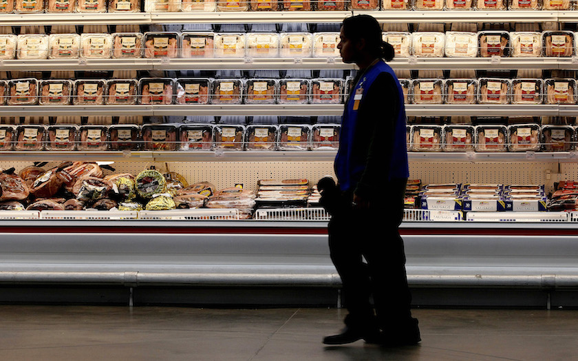 A employee walks by a meat cooler in the grocery section of a Sam's Club during a media tour in Bentonville