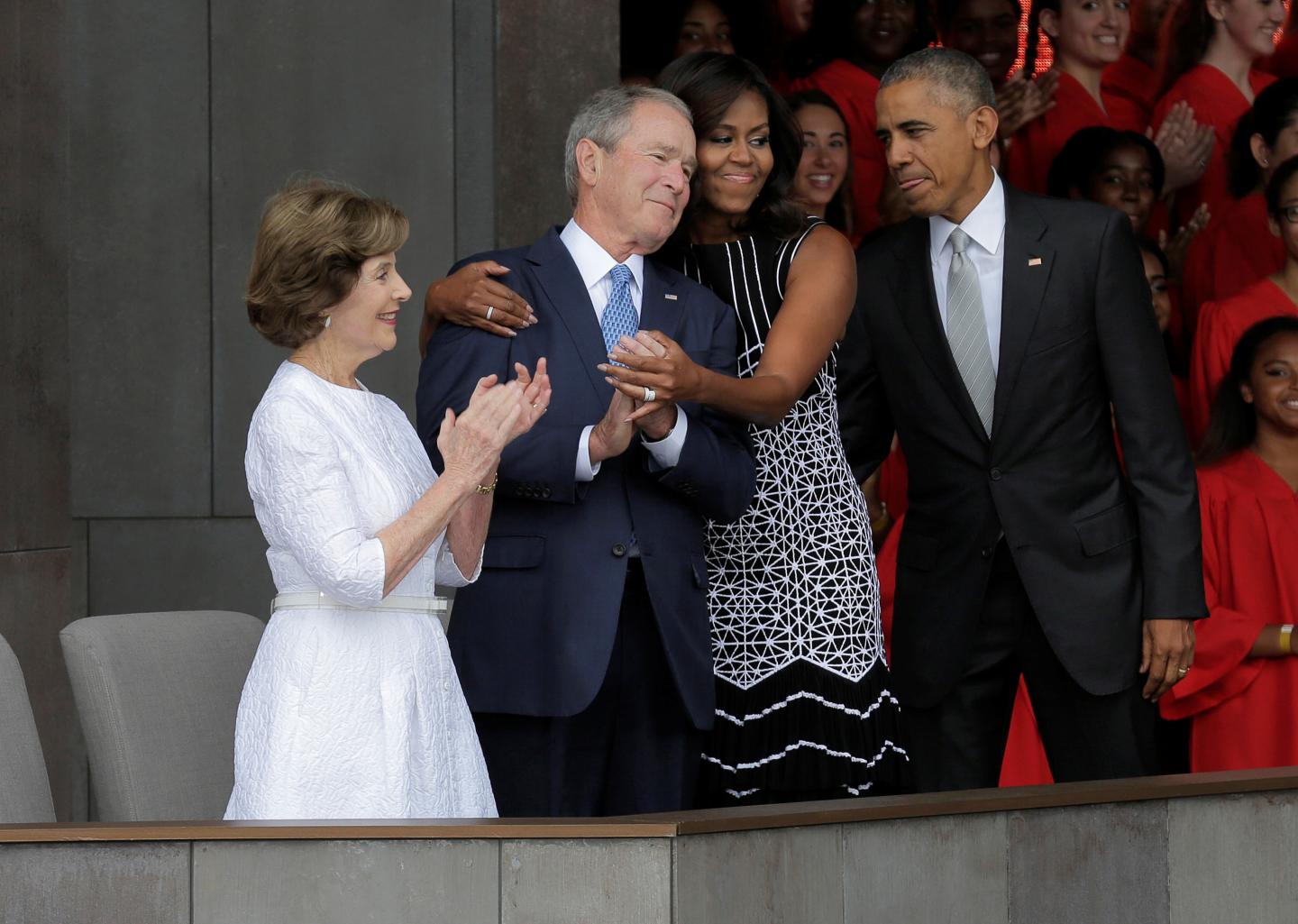 U.S. First Lady Michelle Obama hugs former U.S. President George W. Bush as she arrives for the dedication of the Smithsonians National Museum of African American History and Culture in Washington