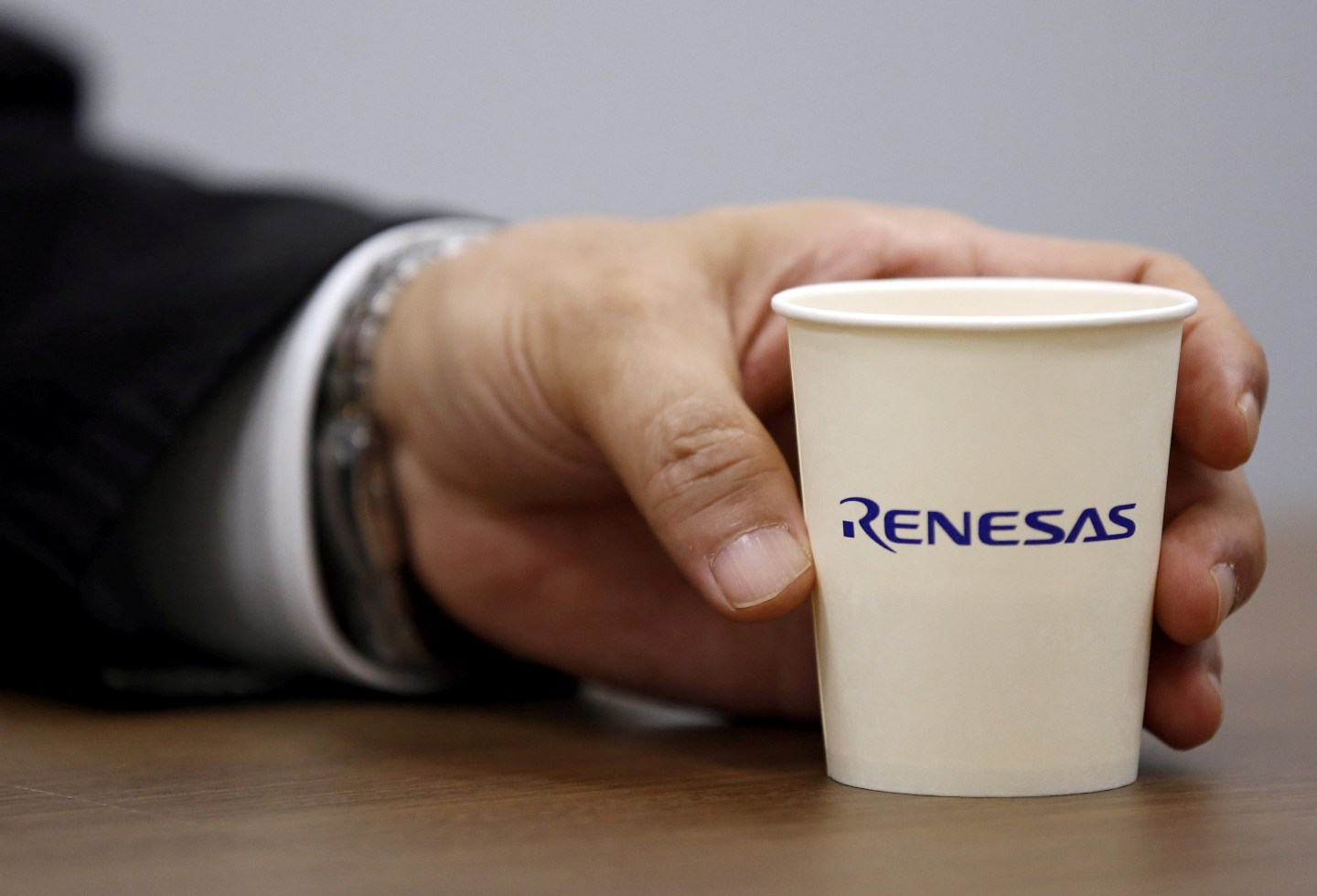 Renesas Electronics Corp's Chief Executive Takao Endo holds a paper cup with the company's logo in Tokyo