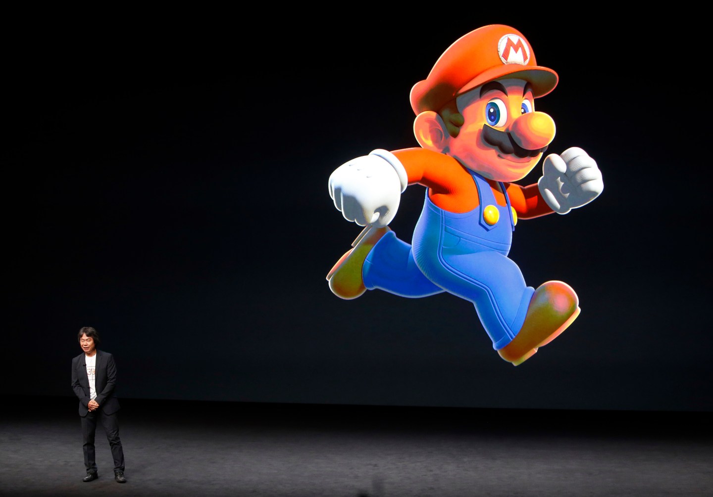 Shigeru Miyamoto stands next to the Super Mario character during an Apple media event in San Francisco