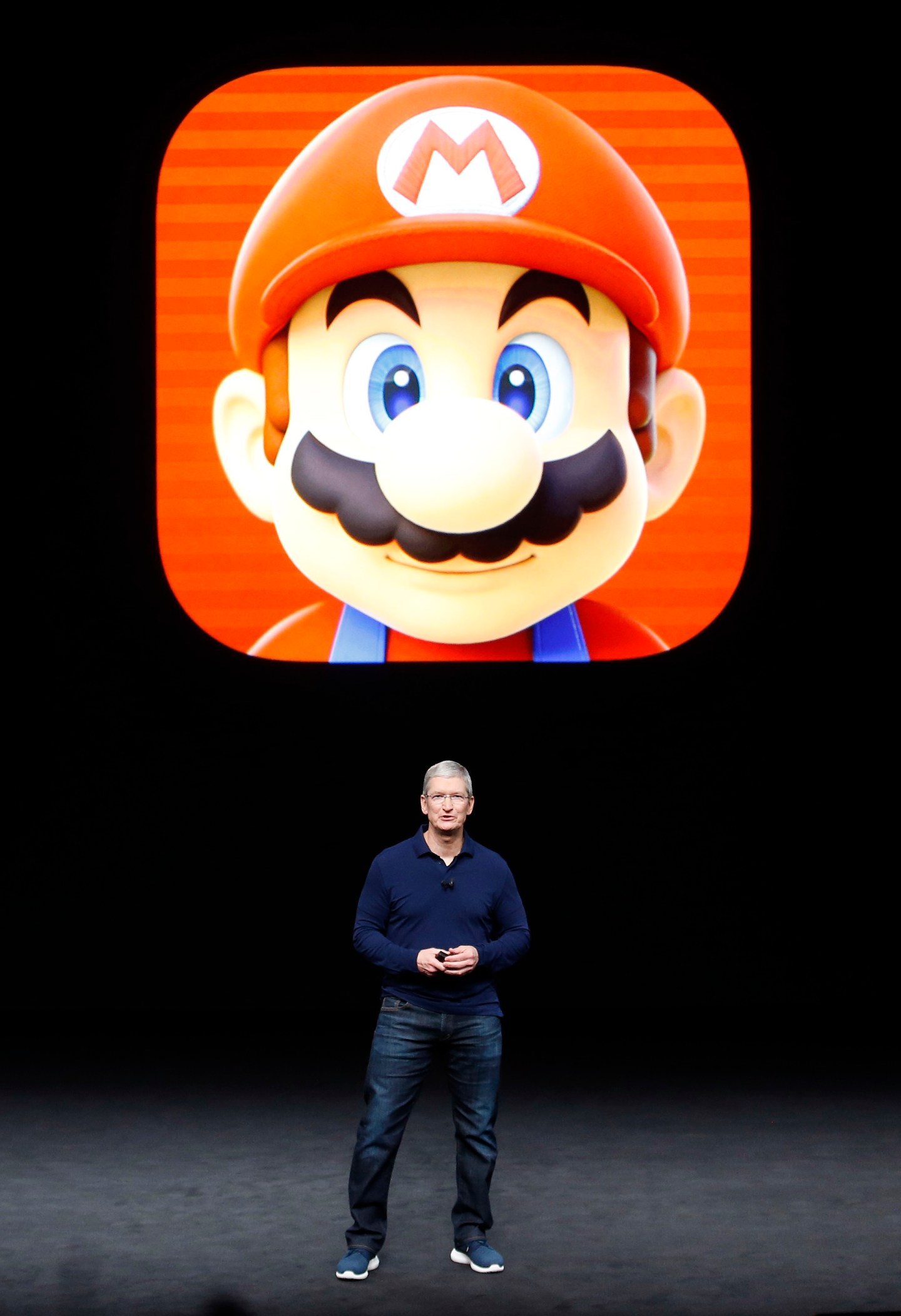 Tim Cook speaks in front of a Mario Bros. image during an Apple media event in San Francisco