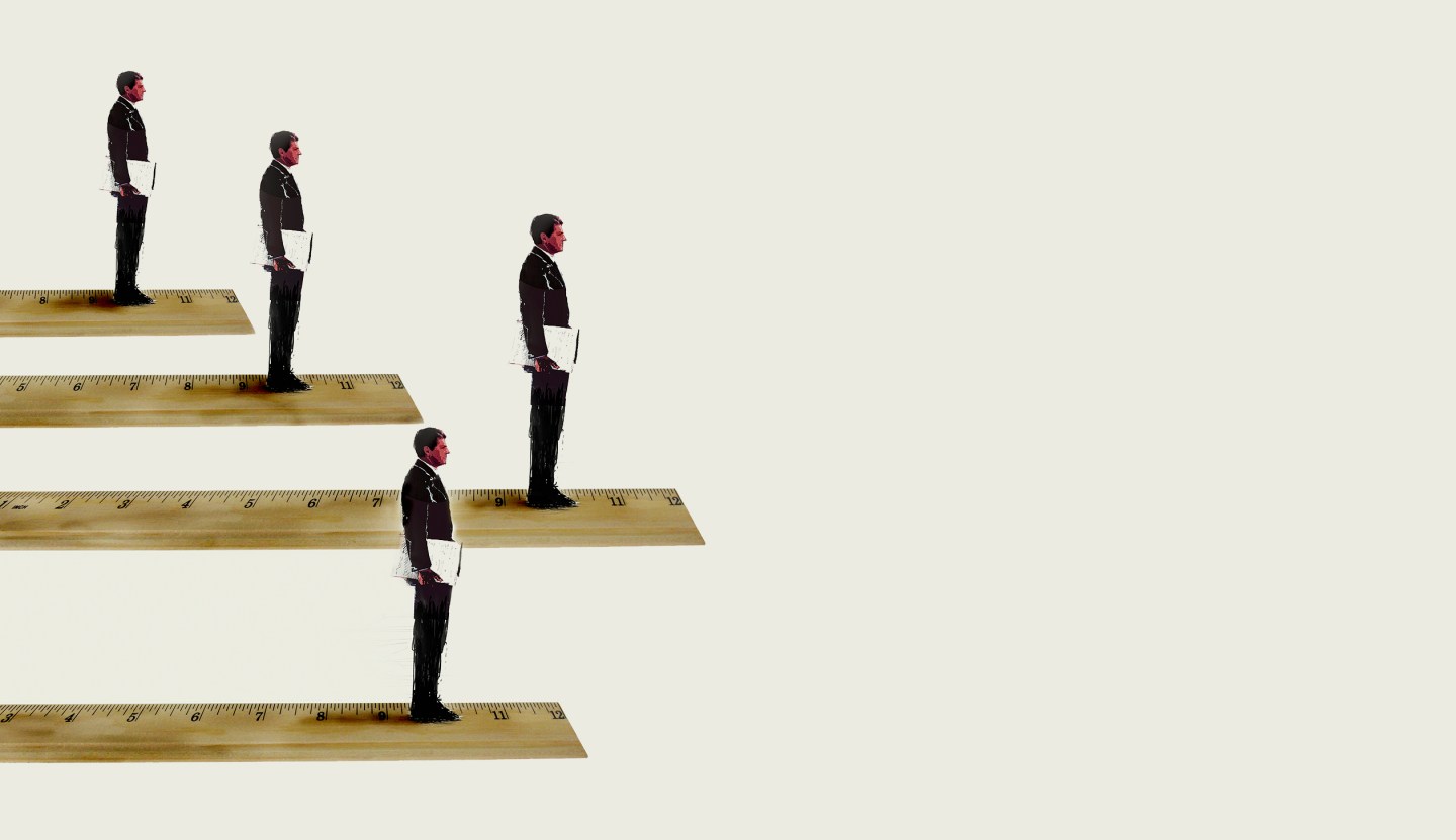 Businessmen standing in rank order on rulers