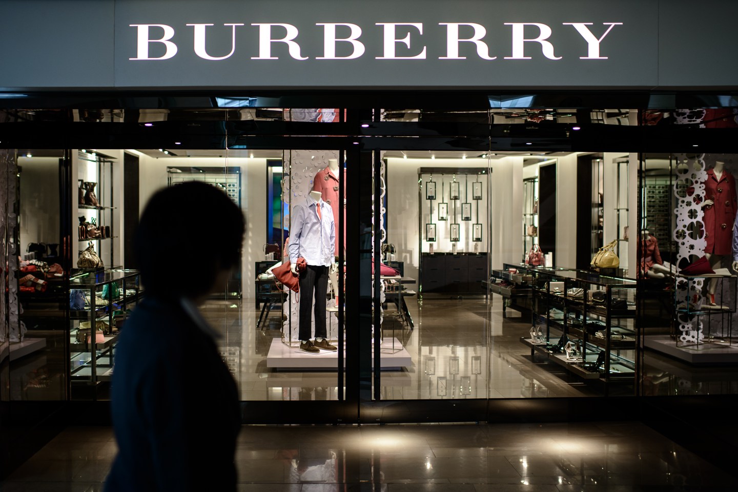 A woman walks past a Burberry store in Hong Kong on February 21, 2014.