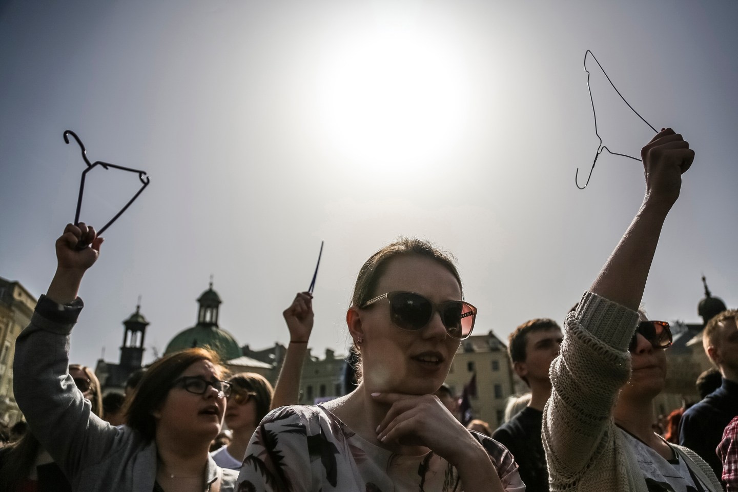 Women demonstrate with clothes hangers at the Main Square in