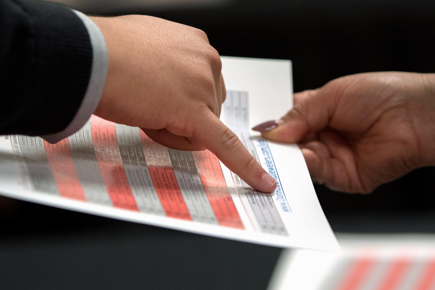 A representative goes over a pamphlet with a job seeker during an Orange County Choice Career Fair in Santa Ana, California, U.S., on Thursday, Oct. 6, 2016.