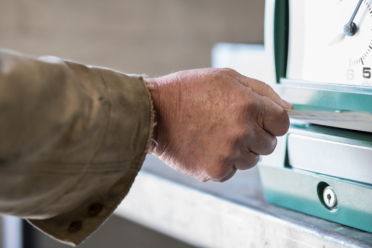 Caucasian worker punching time clock