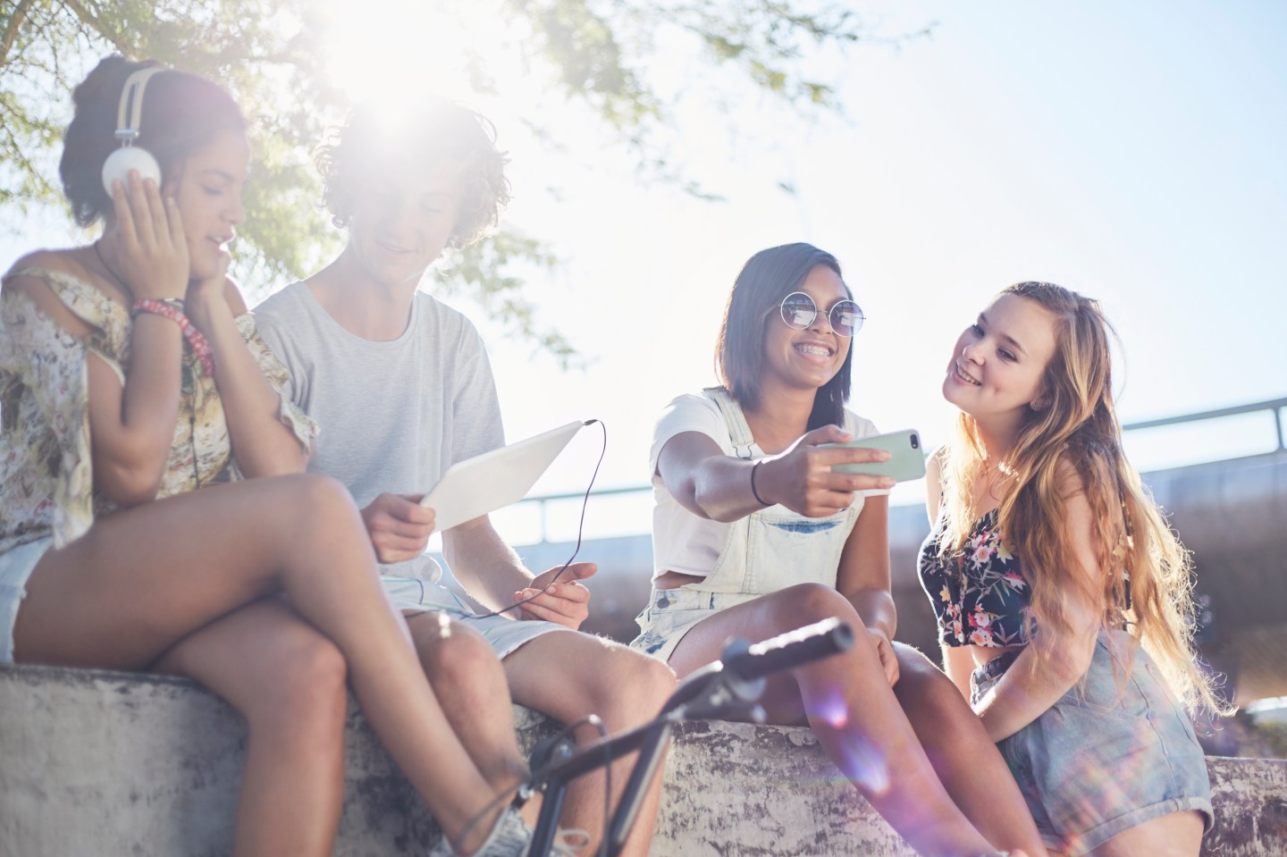 Teenage friends hanging out taking selfie and listening to music