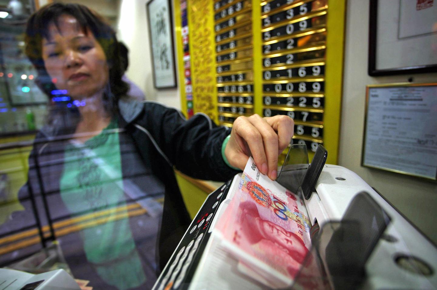 A currency exchange shop owner counts ou